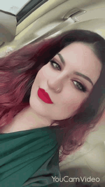 a woman with red lipstick is sitting in a car with the words youcam video on the bottom right