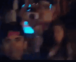 a blurry picture of people in a dark room with a blue light behind them