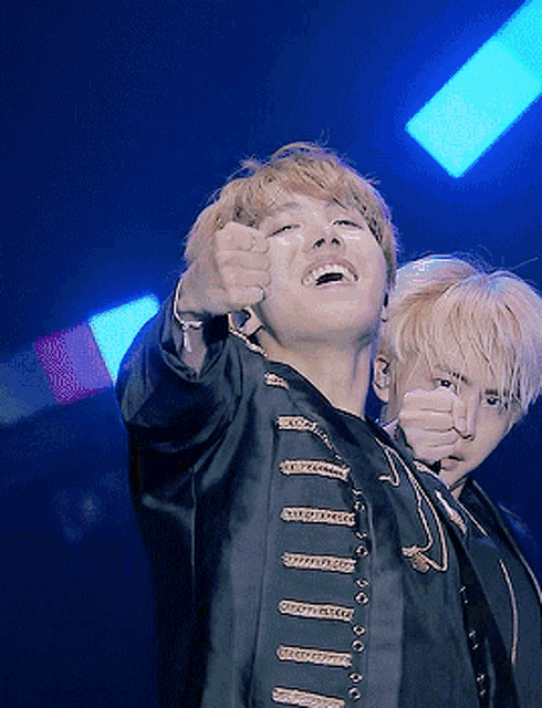a man in a black jacket with gold buttons is pointing