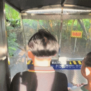 a man sitting in a vehicle with a sign that says warning please remain seat