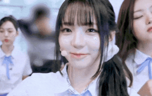 a girl with a microphone in her mouth is smiling and looking at the camera