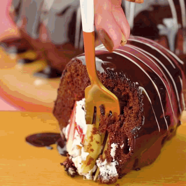 a person is holding a fork over a piece of cake
