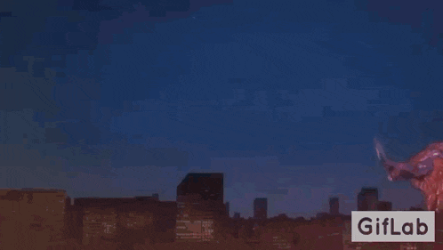 a dragon is flying over a city at night with a pink light coming out of its mouth .
