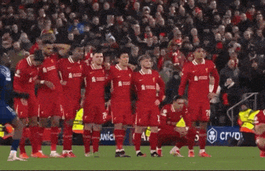 a group of soccer players kneeling down on the field