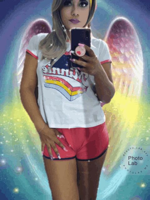 a woman taking a picture of herself with a shirt that says sinful