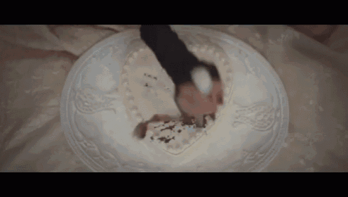 a person cutting a heart shaped cake on a white plate