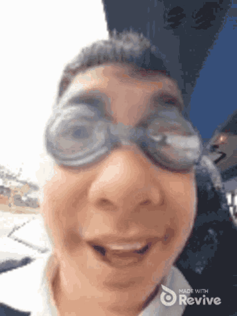 a close up of a person wearing goggles and making a funny face .