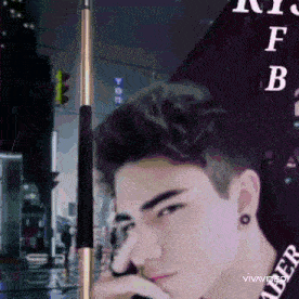 a young man is standing in front of a sign that says ' ny f b '