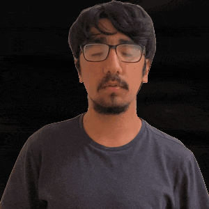 a man with glasses and a beard is looking down