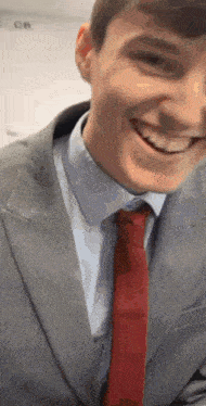 a man in a suit and tie is smiling