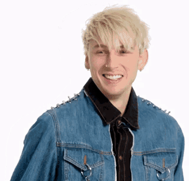 a young man wearing a blue denim jacket with spikes on it