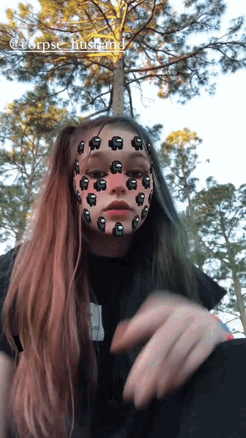 a girl with among us on her face is wearing a corpse husband shirt