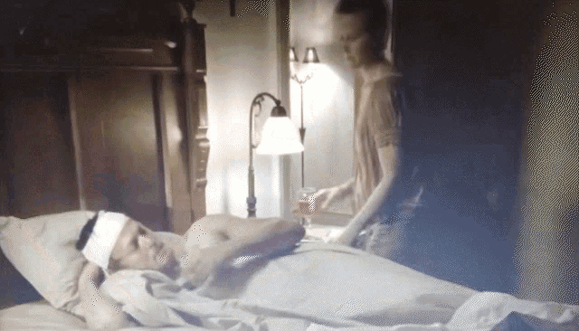 a man with a bandage on his head is laying on a bed