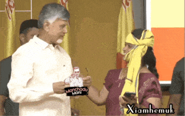 a man and a woman are standing next to each other and the man is wearing a manchodu mani sticker on his shirt