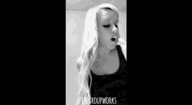 a black and white photo of a woman with a white liquid coming out of her mouth