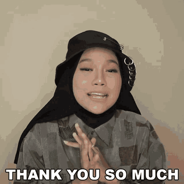 a woman wearing a hijab and a hat is saying thank you so much