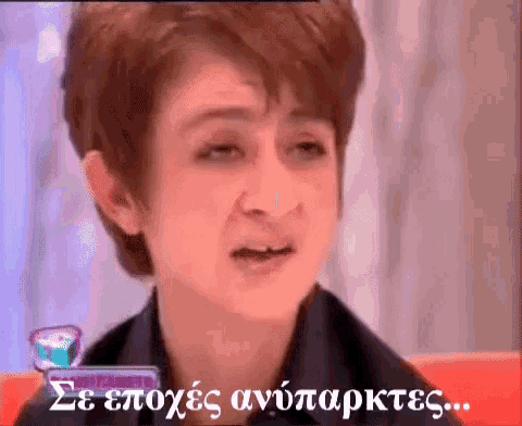 a woman is crying in front of a sign that says se epoxees antypopktes