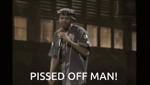 a man stands in front of a microphone with the words pissed off man below him
