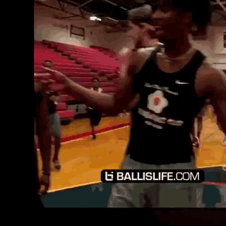 a man stands on a basketball court with a ballislife.com logo on the bottom right