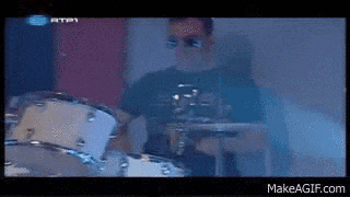 a man wearing sunglasses is playing drums on a makeagif.com website