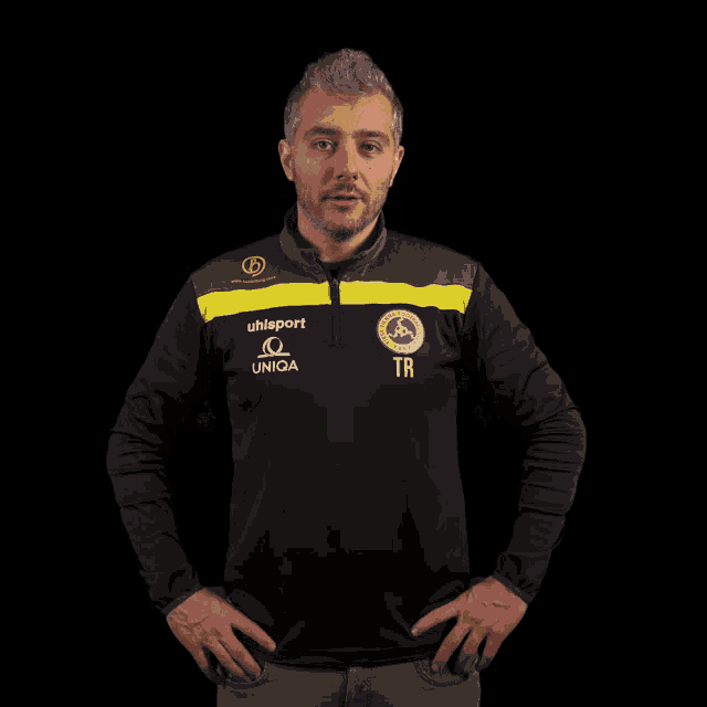 a man wearing a black and yellow shirt that says uhlsport and uniga