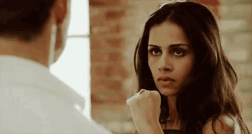 a woman is punching a man in the face .