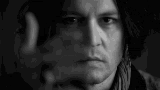 a black and white photo of a man 's face with a scarf around his neck