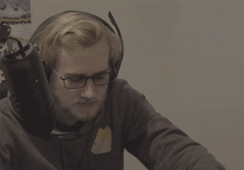 a man wearing headphones and glasses is making a gesture