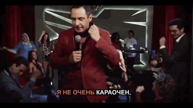 a man in a red jacket is holding a microphone and says i 'm not very karaochen