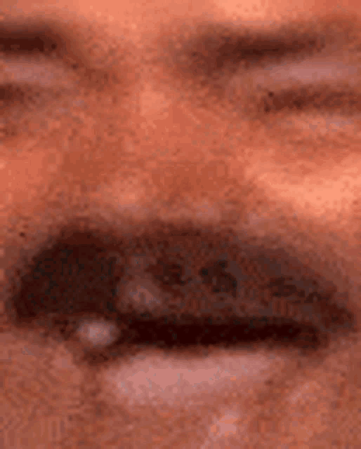 a close up of a man 's face with his eyes closed and his mouth open .
