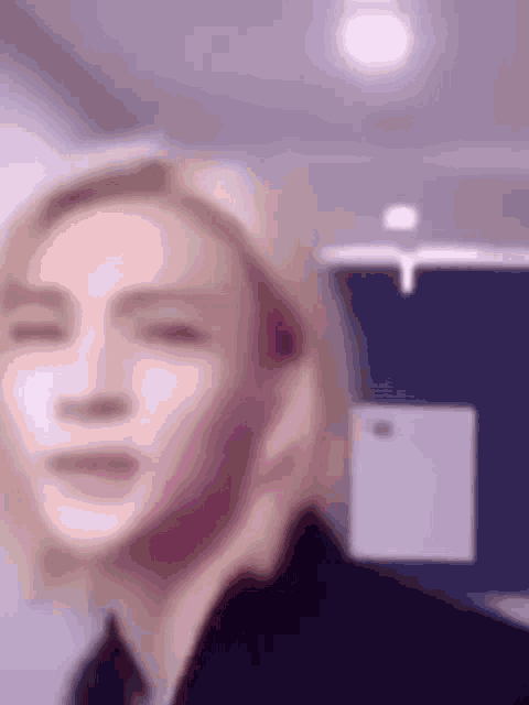 a blurry picture of a person 's face with a purple background .