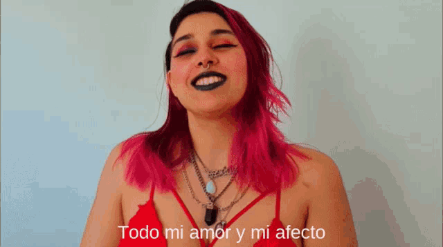 a woman with pink hair and black makeup says todo mi amor y mi afecto