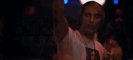 a man wearing headphones is dancing in a club while a woman watches .
