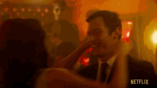 a man in a suit and tie is dancing with a woman in a club .