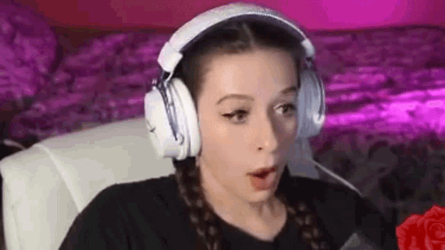a woman wearing headphones is sitting in a chair and looking surprised .