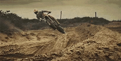 a man is doing a trick on a dirt bike in the dirt
