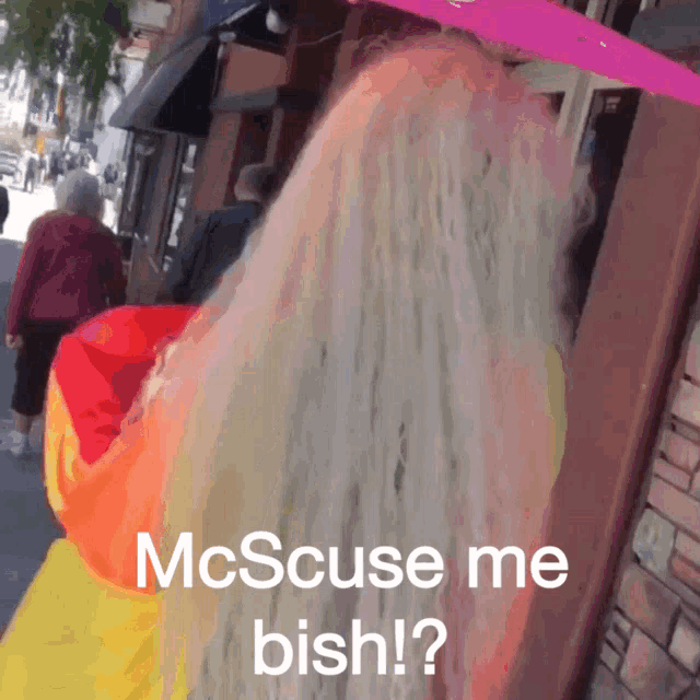 a woman with long blonde hair is walking down a street with a sign that says mcscuse me bish ?