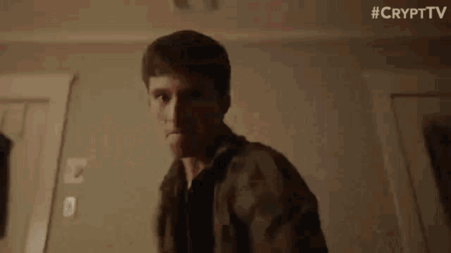 a man is standing in front of a door in a dark room .