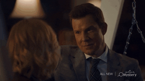 a man and a woman kissing in a hallmark mystery advertisement