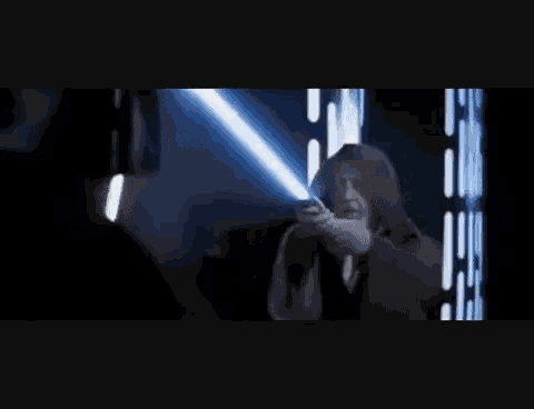 a person is standing in a dark room with a light coming out of a window