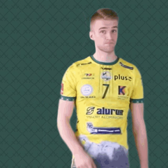 a man wearing a yellow shirt that says plus k on it