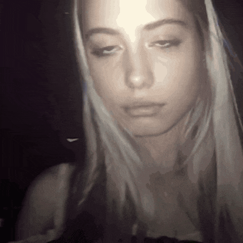 a close up of a woman 's face in a dark room