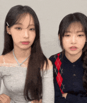 two girls are standing next to each other and one is wearing a plaid shirt