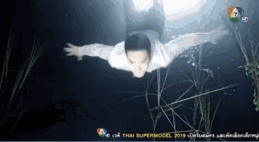 a man is swimming in the water with the words thai supermodel 2019 on the bottom right