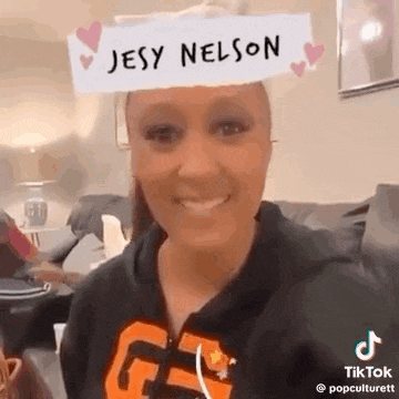 a woman wearing a jesy nelson hat is smiling .