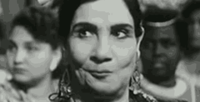 a black and white photo of a woman making a funny face in a crowd .