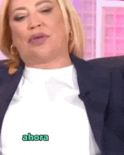 a woman is wearing a white shirt and a blue jacket and has a sticker on her shirt that says ahora .