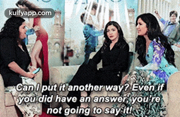 a group of women are sitting on a couch and talking .