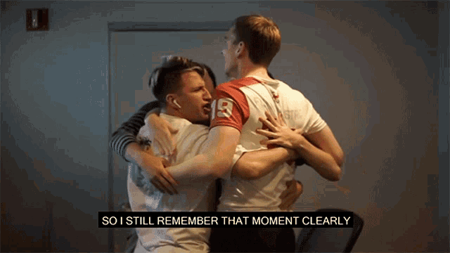 a group of young men hugging each other with the number 19 on their shirt