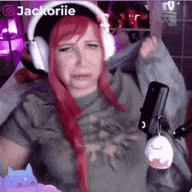 a woman with red hair is wearing headphones and holding a microphone